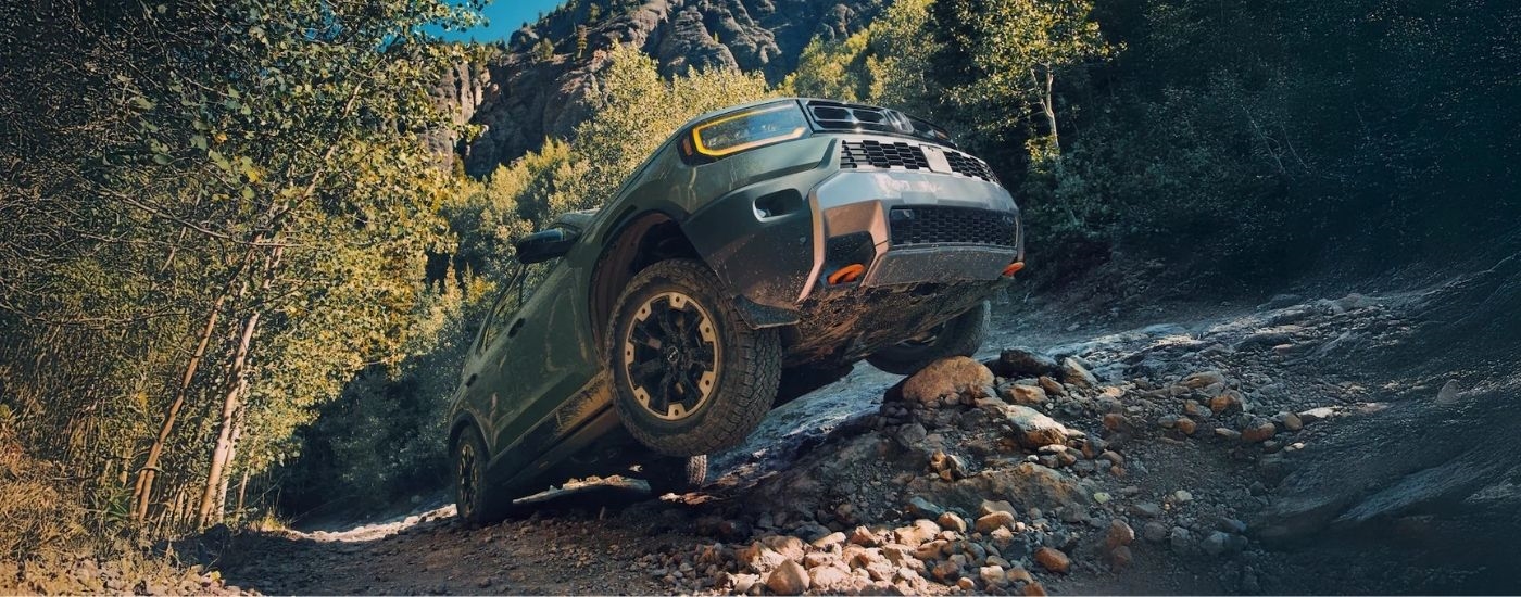 A green 2026 Honda Passport Trailsport is shown off-road.