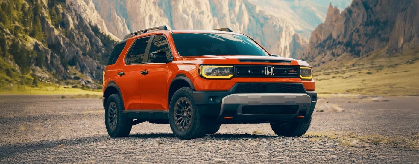 An orange 2026 Honda Passport Trailsport is angled right.