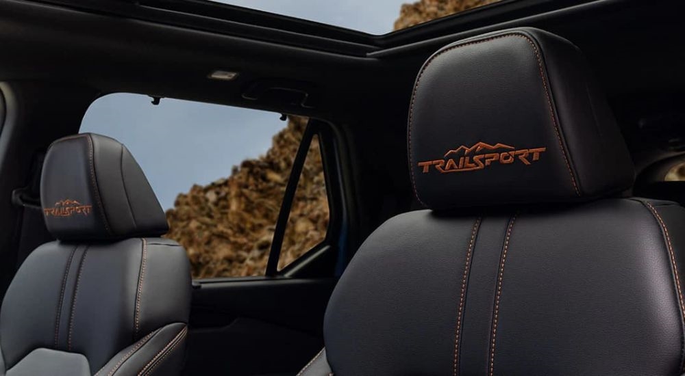 A close-up shows the orange 'TrailSport' badge on a 2025 Honda Pilot TrailSport.