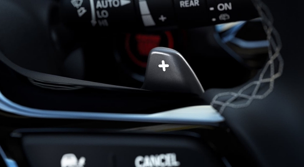 A close-up shows the black paddle shifter in a 2023 Honda Civic Sport Touring.
