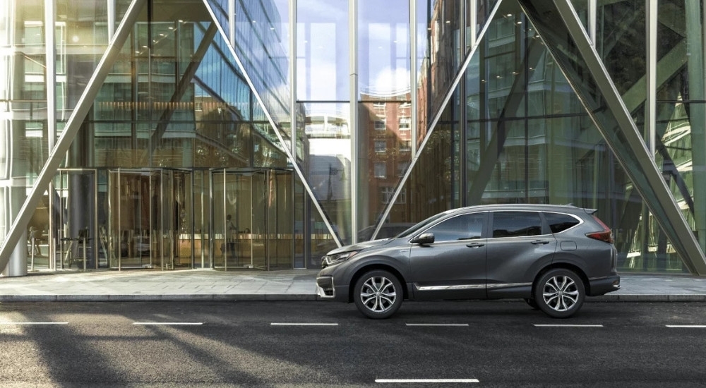 A grey 2022 Honda CR-V Hybrid Touring is shown in front of a modern building.