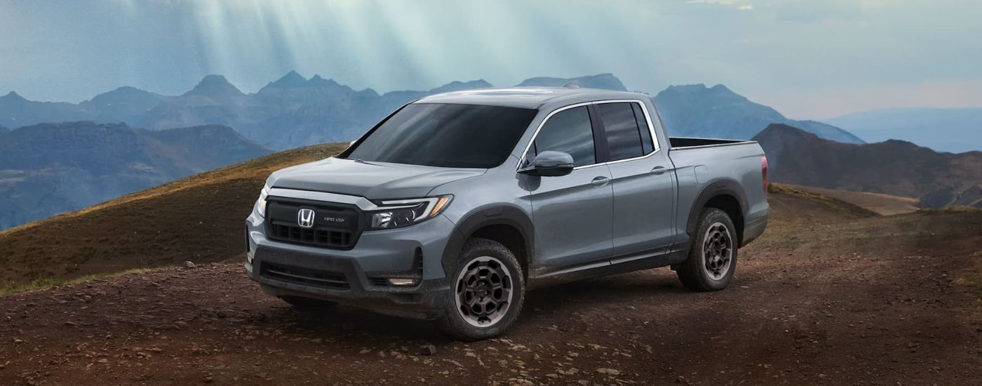 A grey 2025 Honda Ridgeline RTL HPD+ parked off-road and angled left.