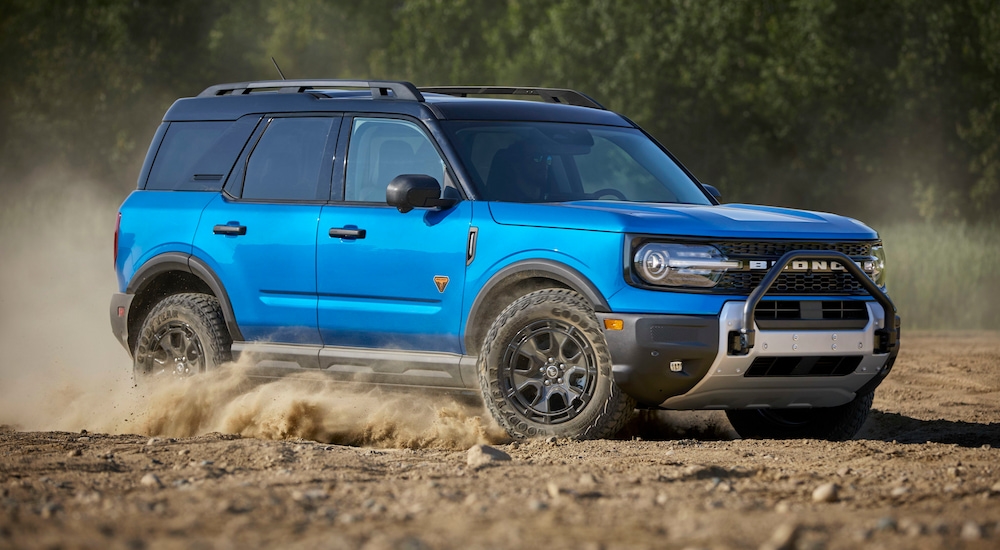 A blue 2025 Ford Bronco Sport Badlands Sasquatch off-roading through a sandy area.