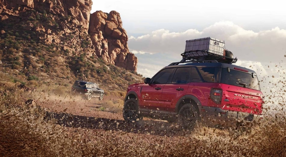 Rear view of a red 2025 Ford Bronco Sport Badlands kicking up mud while off-roading.