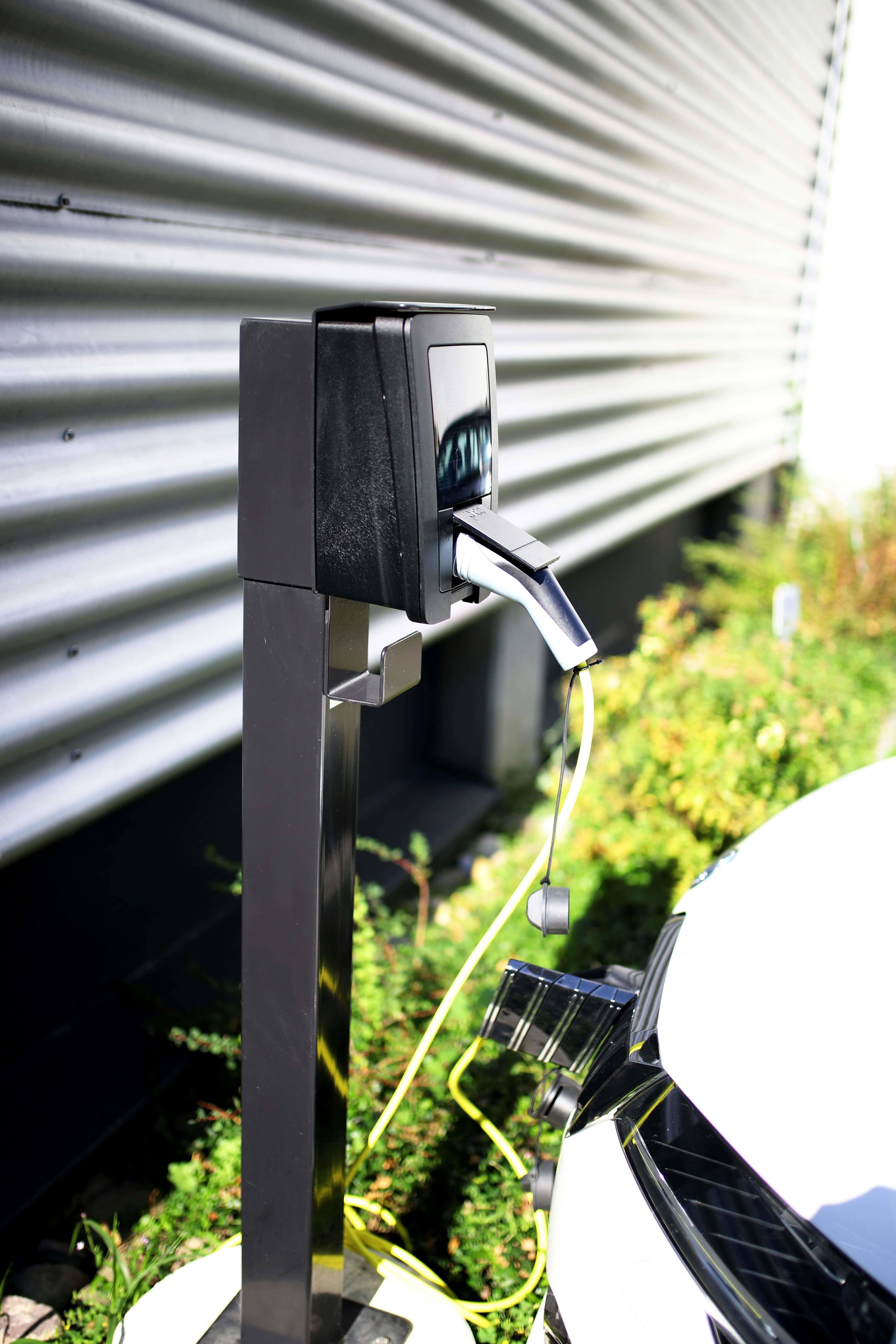 A home EV charging station plugged into an electric vehicle