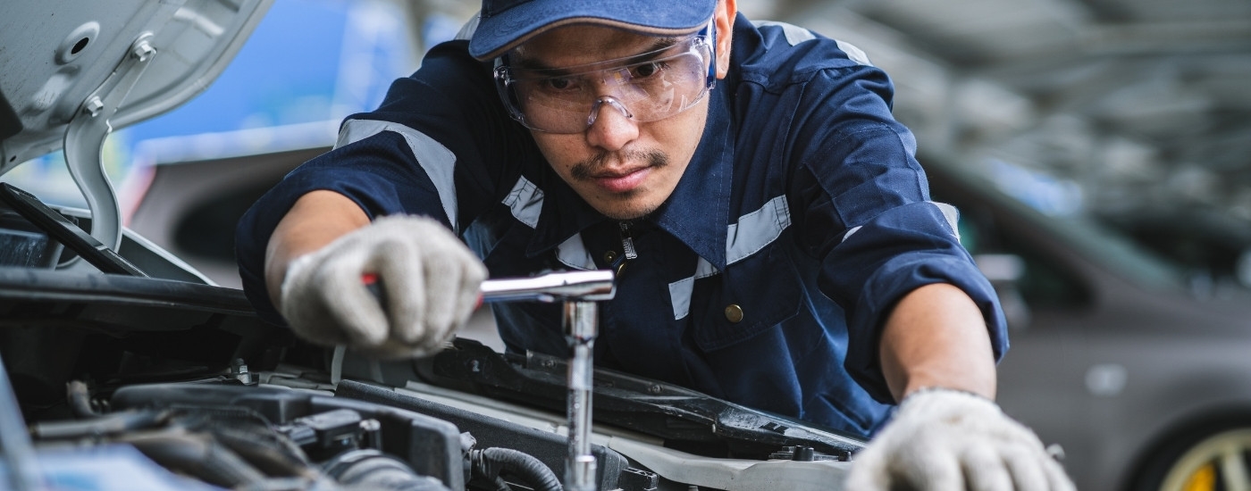 A mechanic is shown servicing a vehicle.