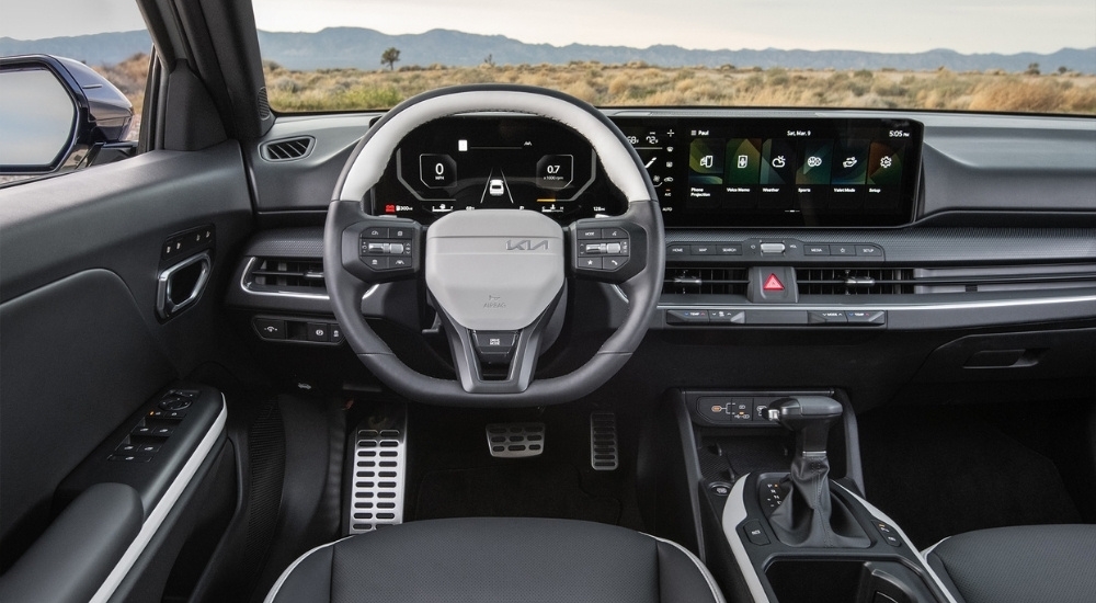 The interior of a 2025 Kia K4 is shown from the driver’s seat.