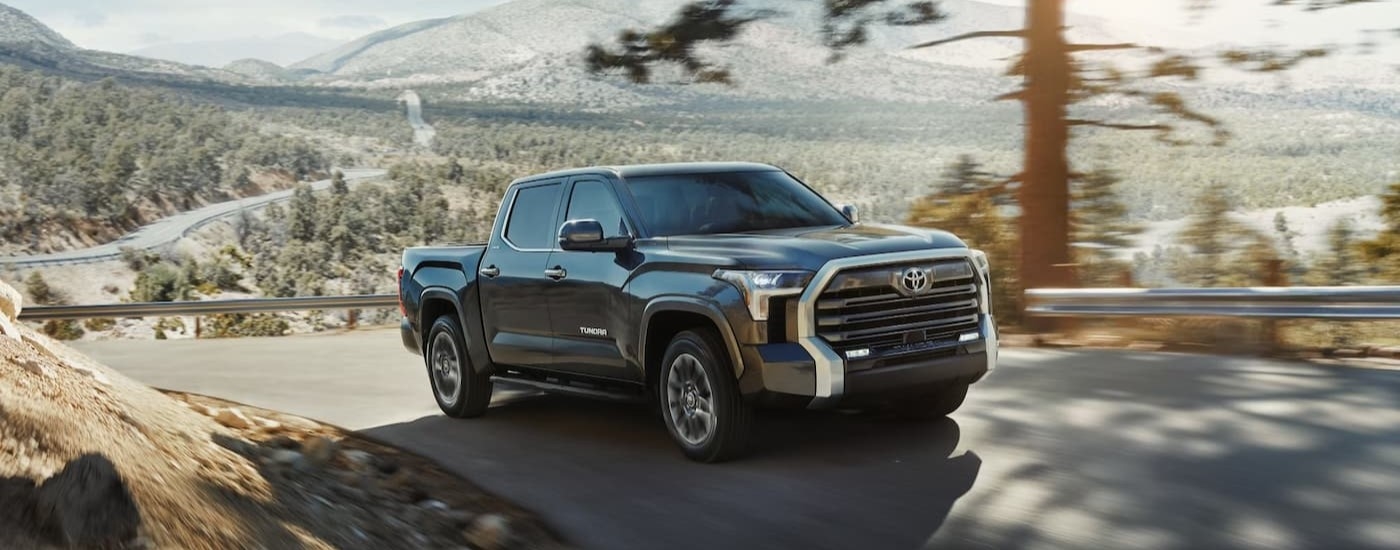 A black 2025 Toyota Tundra for sale near Auburn is shown driving on a mountain.