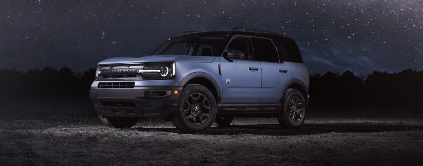 A blue 2024 Ford Bronco Sport Big Bend parked off-road at night.