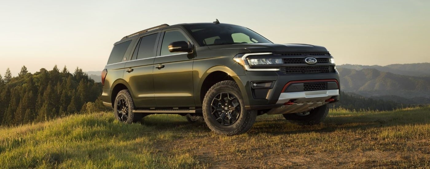 Right-angled view of a green 2023 Ford Expedition Timberline parked on a grassy hill.