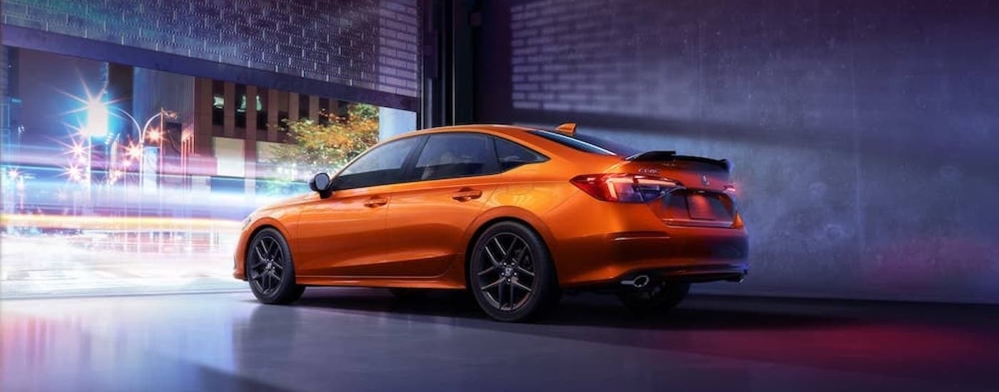 An orange 2022 Honda Civic Si is shown leaving a parking garage after leaving a dealer that has a used Honda Civic for sale near Union City.