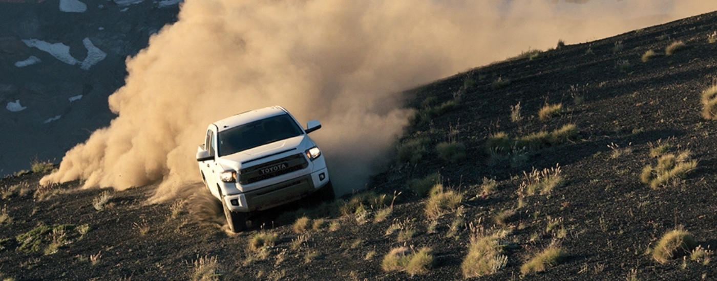 A white 2015 Toyota Tundra for sale near Franklin is shown kicking up dust off-road.