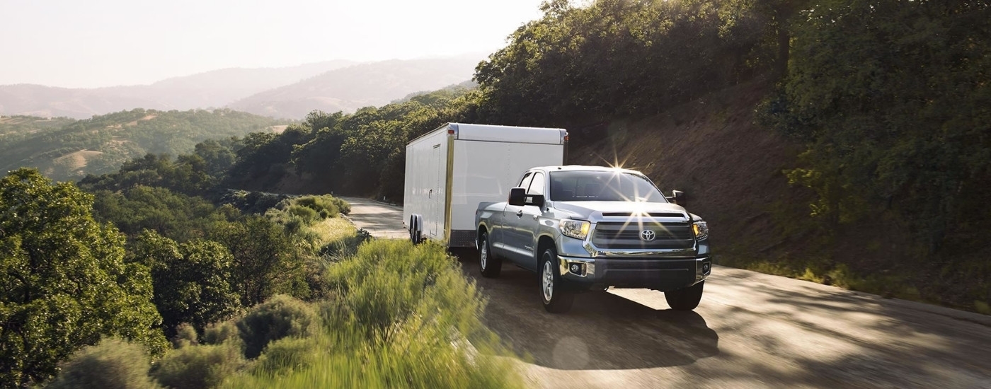 A grey 2016 Toyota Tundra for sale near Russellville is shown towing a trailer.