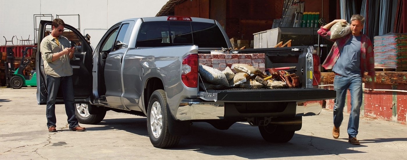 Workers are shown near a grey 2016 Toyota Tundra for sale near Brownsville.