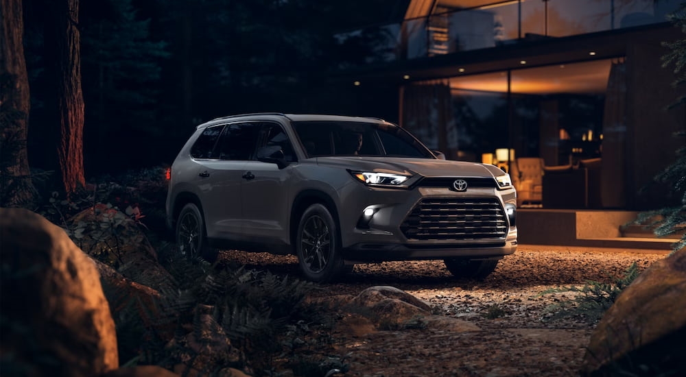 A grey 2025 Toyota Grand Highlander parked outside of a building.