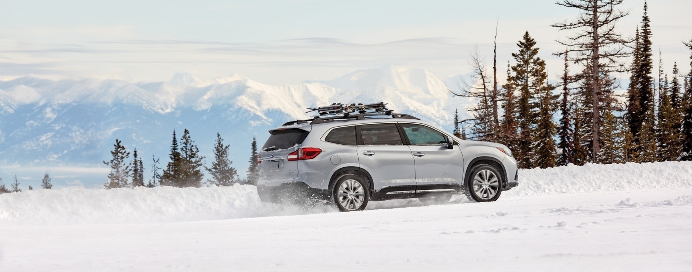 A silver 2020 Subaru Ascent for sale in Rhinebeck is shown driving on a snowy trail.