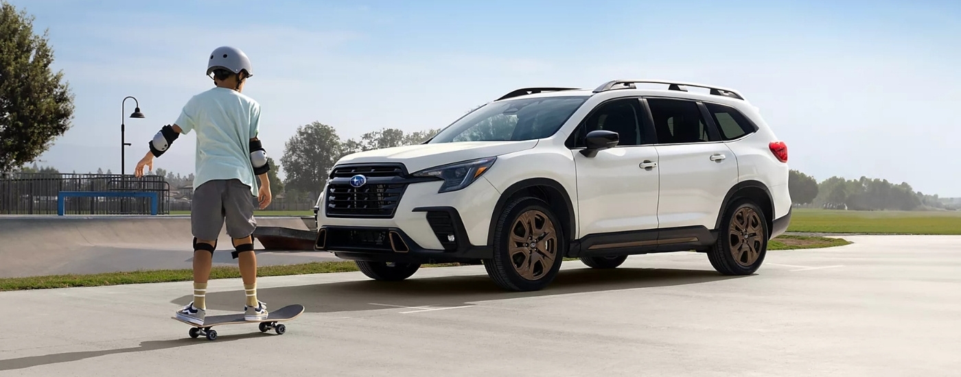 A skateboarder is shown near a white 2025 Subaru Ascent Bronze Edition.