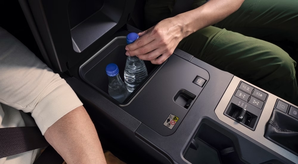 A close-up shows bottled water in the center console of a 2025 Toyota Land Cruiser.