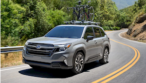 Family enjoying the outdoors while sitting in the rear of a red 2025 Subaru Outback