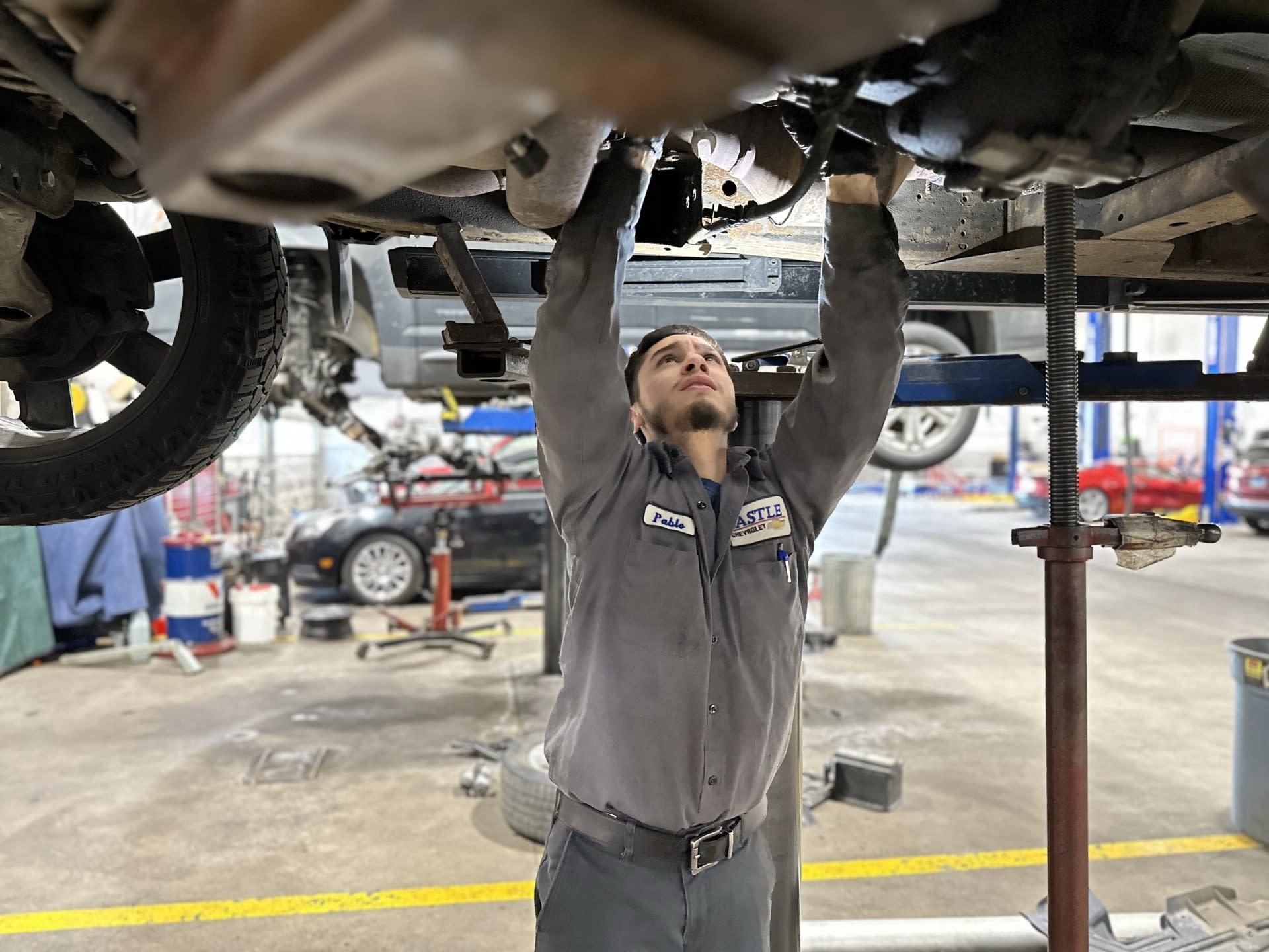 service technician working on vehicle at castle cars