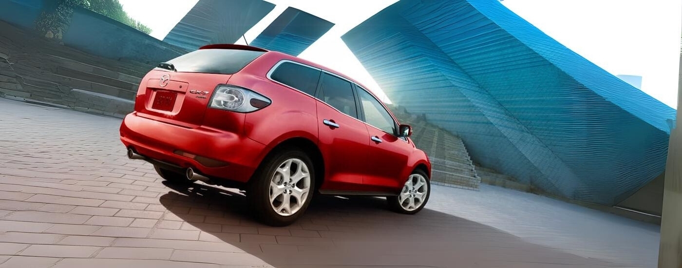 A red 2012 Mazda CX-7 is parked on a courtyard.