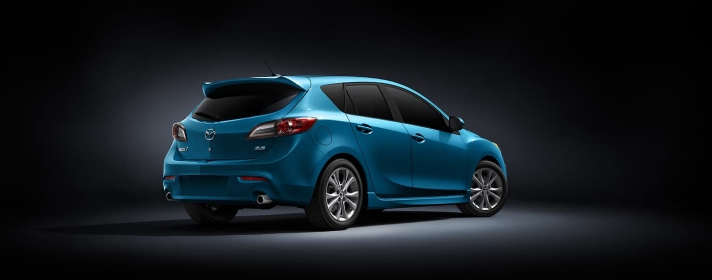 A blue 2010 Mazda3 is shown against a black backdrop.