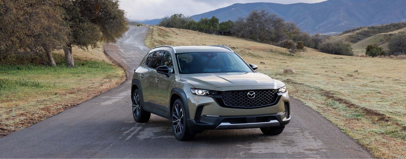 A green 2023 Mazda CX-50 for sale is parked on pavement.