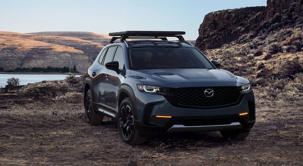 A grey 2025 Mazda CX-50 parked by a lake after visiting a Mazda dealership near Tomball.