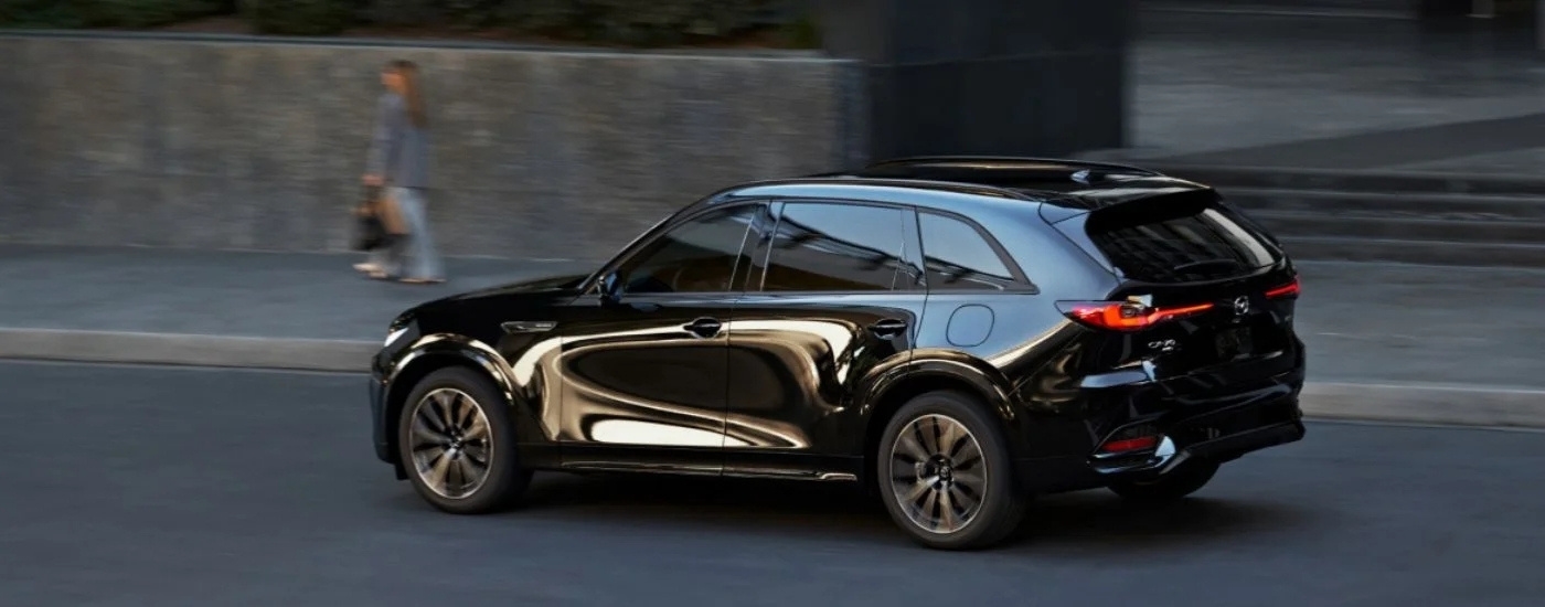 A black 2025 Mazda CX-70 driving to a Mazda dealer near Cypress.