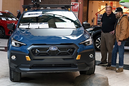 Two men discussing features on a 2025 Subaru Crosstrek Wilderness at the Galleria Mall