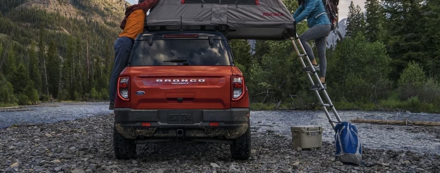 A red 2025 Ford Bronco Sport is shown from the rear while off-road.