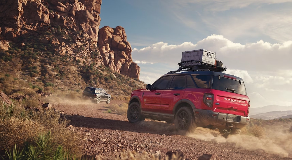 Rear view of a red 2025 Ford Bronco Sport driving on a trail.