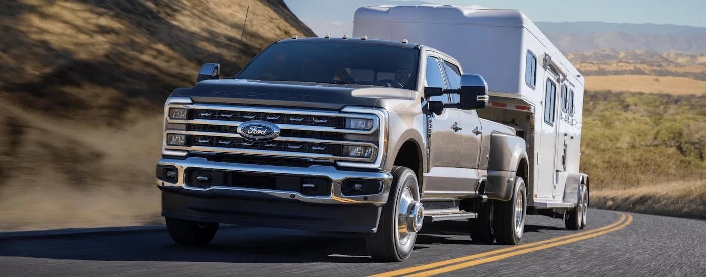 A grey 2025 Ford F-350 for sale is shown from the front while towing.
