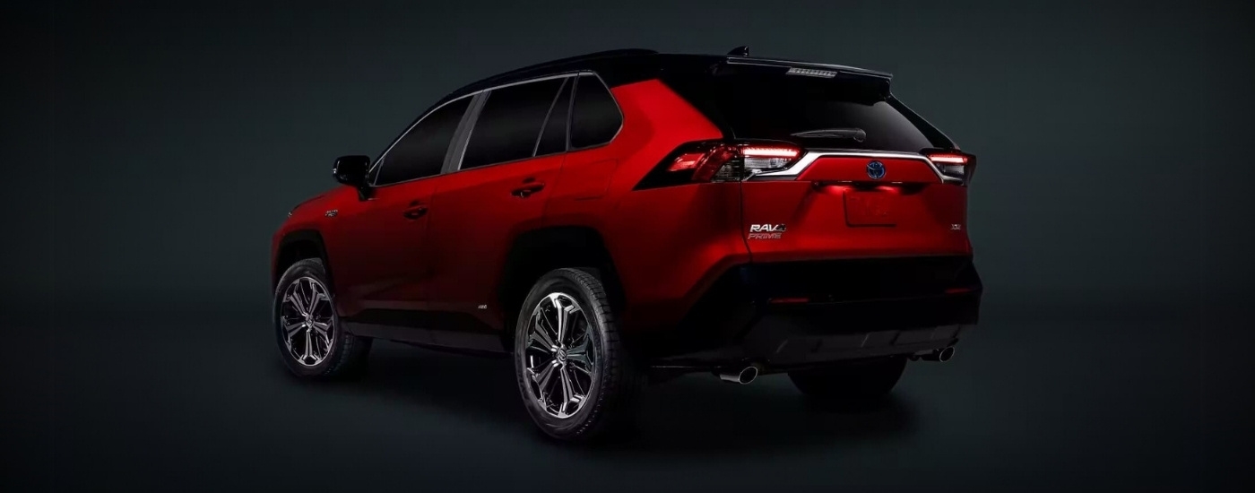 A red 2023 Toyota RAV4 PHEV parked against a dark background.