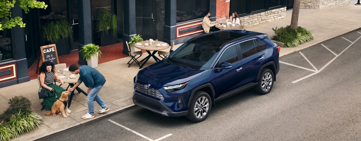 A blue 2025 Toyota RAV4 for sale near Claremont parked near a cafe.