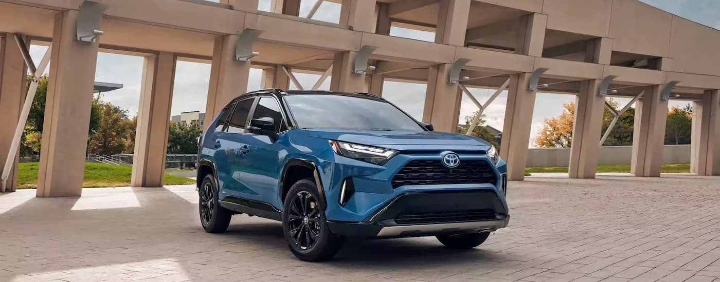Blue used 2023 Toyota RAV4 for sale in Yonkers parked in a courtyard.