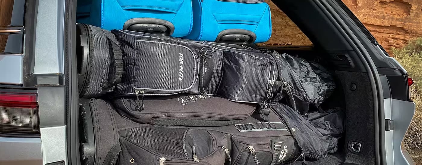 Gold clubs and luggage in the back of a grey 2025 Jeep Grand Cherokee.