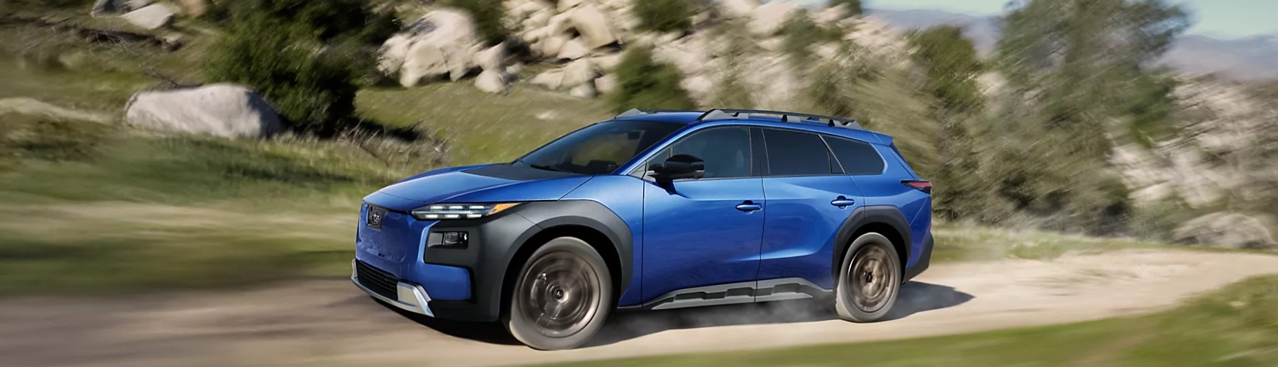 2026 Subaru Trailseeker EV driving through rugged terrain