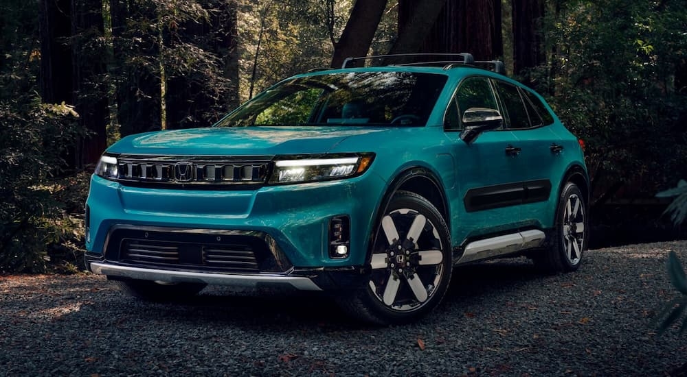 A blue 2025 Honda Prologue parked in a forest.