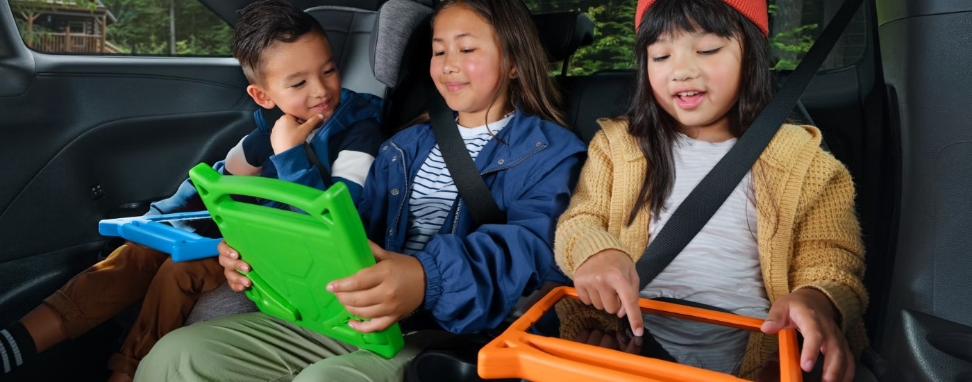 Kids using tablets in a 2025 Toyota Sienna Woodland Edition.