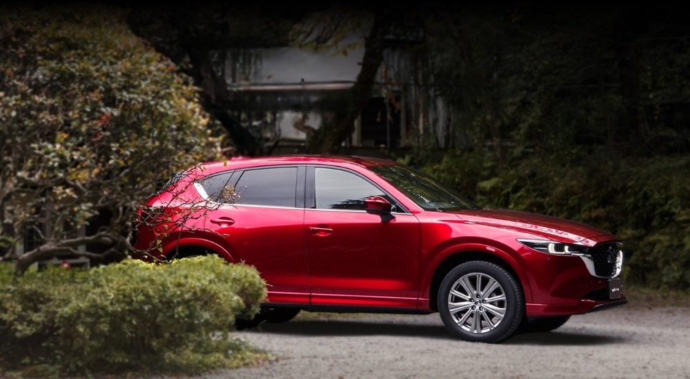 A red 2025 Mazda CX-5 parked on a driveway.