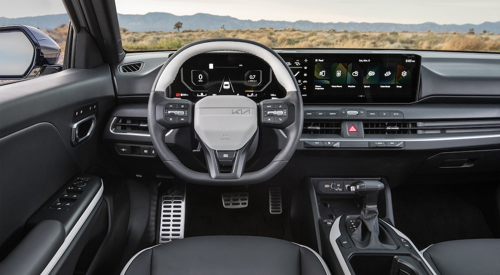 White steering wheel and dashboard inside a 2025 Kia K4.