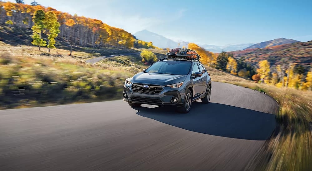 Grey 2025 Subaru Crosstrek Premium for sale near Millbrook driving on a forest road.