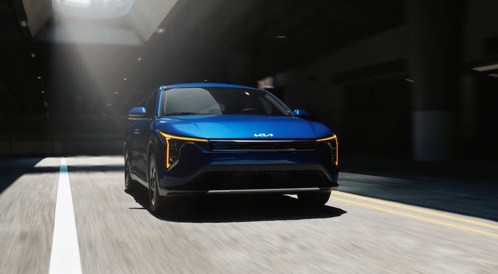 Blue 2025 Kia K4 driving in a tunnel.