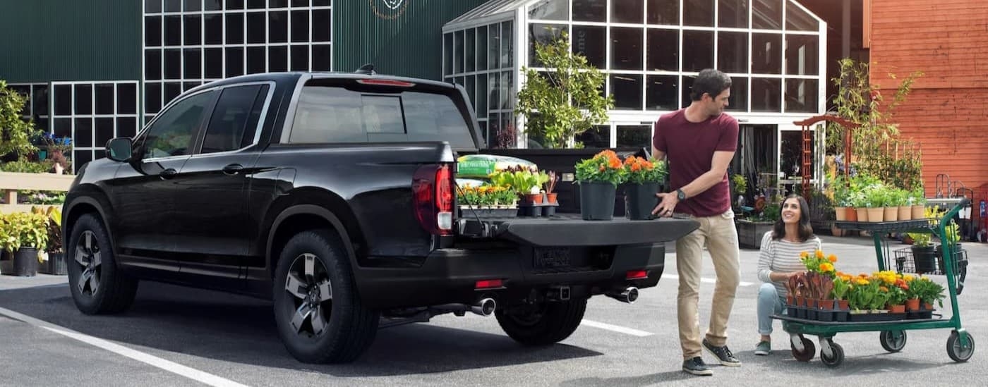 A black 2024 Honda Ridgeline RTL parked at a greenery.