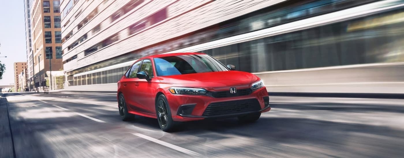 A red 2022 Honda Civic driving to view a used Honda for sale in Miami.