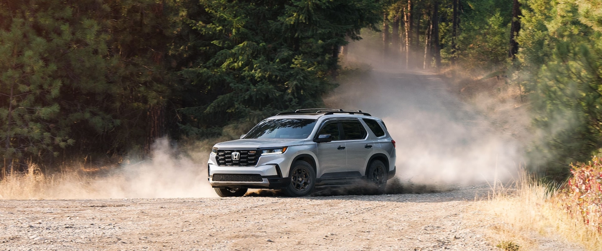 White 2025 Honda Pilot TrailSport for sale near Seattle driving down a dirt road.