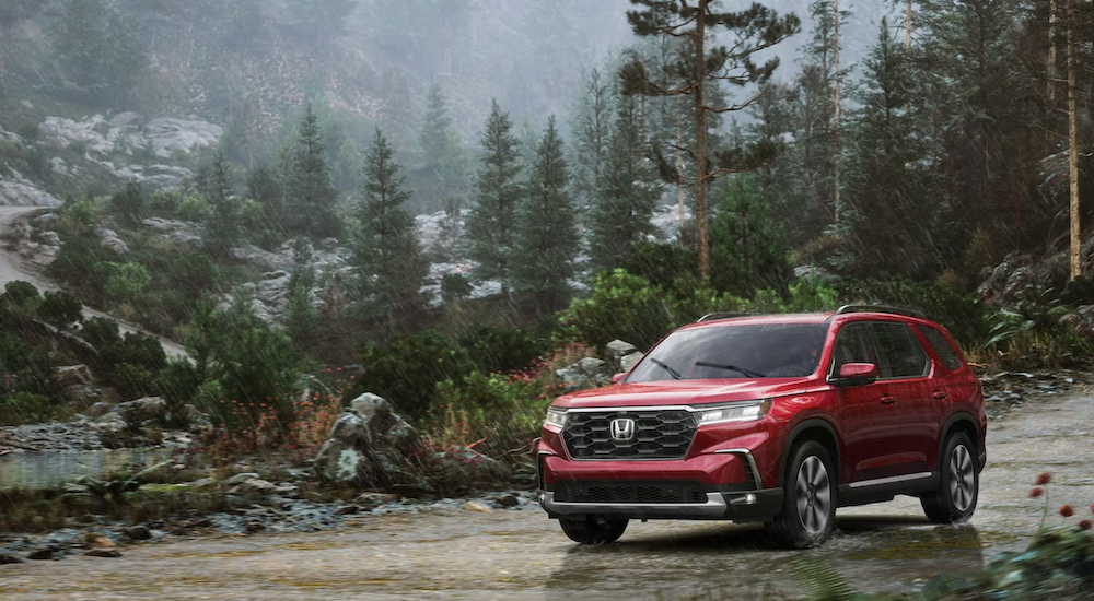 Red 2025 Honda Pilot for sale near Seattle parked off-road.