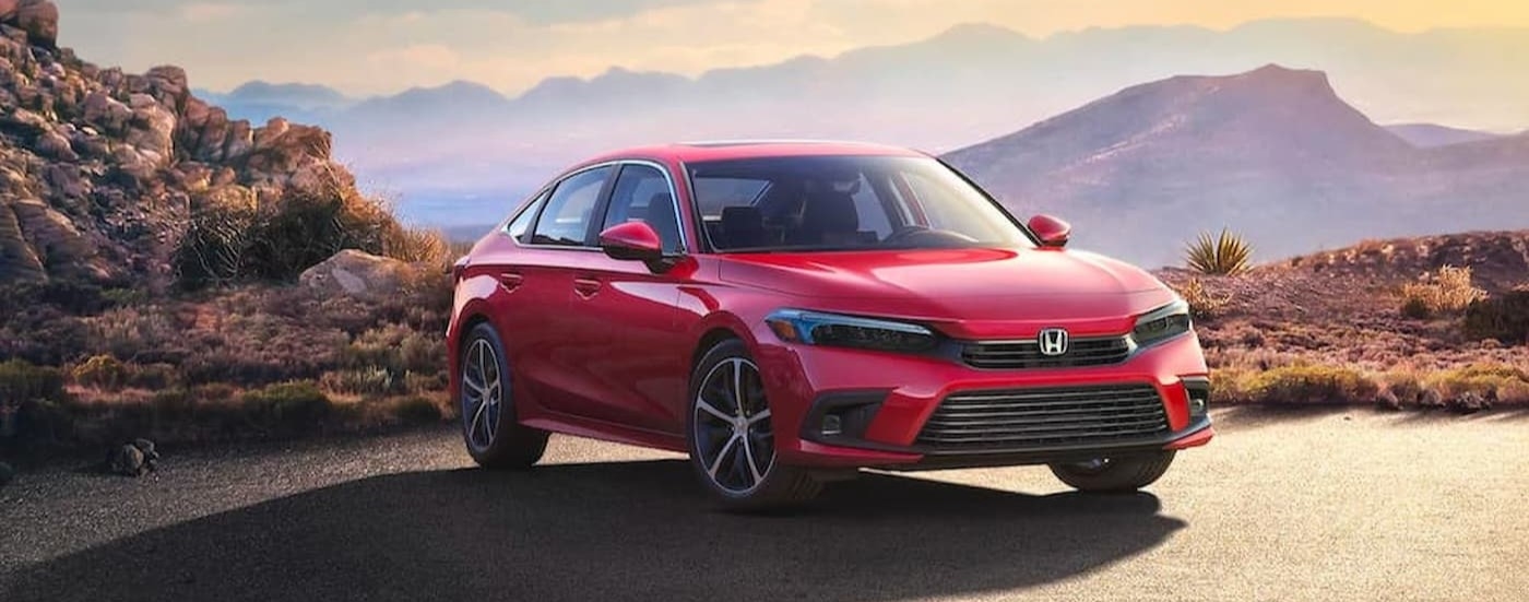 A red 2023 Honda Civic Touring parked on a sunny day.