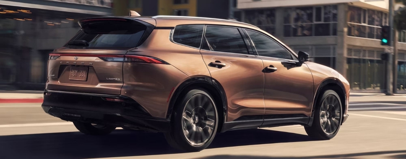 A bronze 2025 Toyota Crown Signia Limited driving on a city street.